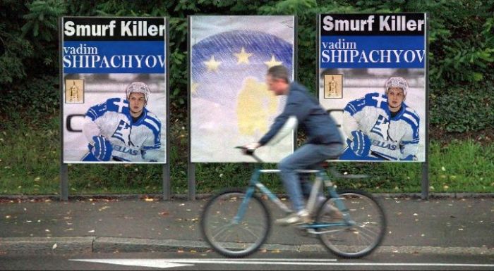 A Greek man rides past signs proclaiming Athens forward Vadim Shipachyov the "Smurf Killer" in advance of this week's second round EURO League playoff series between the Greeks and Berlin.